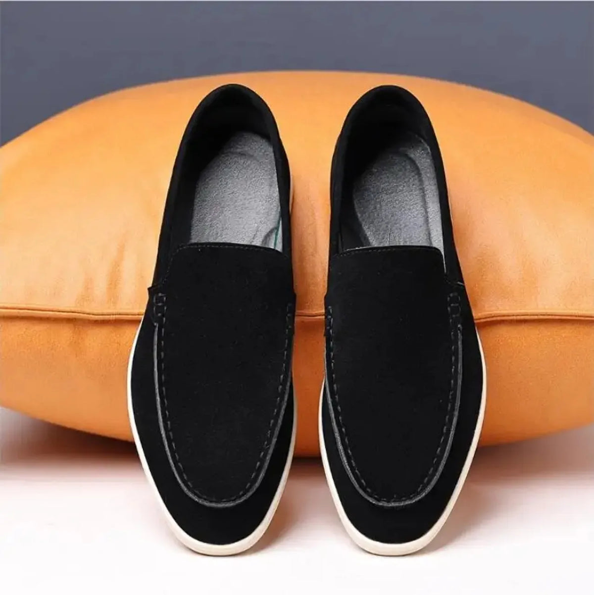 Mocassim casual de camurça preta, sem cadarço, com costuras e solado branco