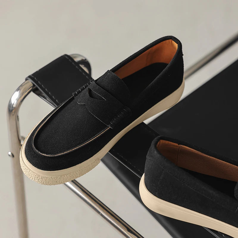 Mocassim tipo loafer preto de camurça com tira decorativa e solado claro