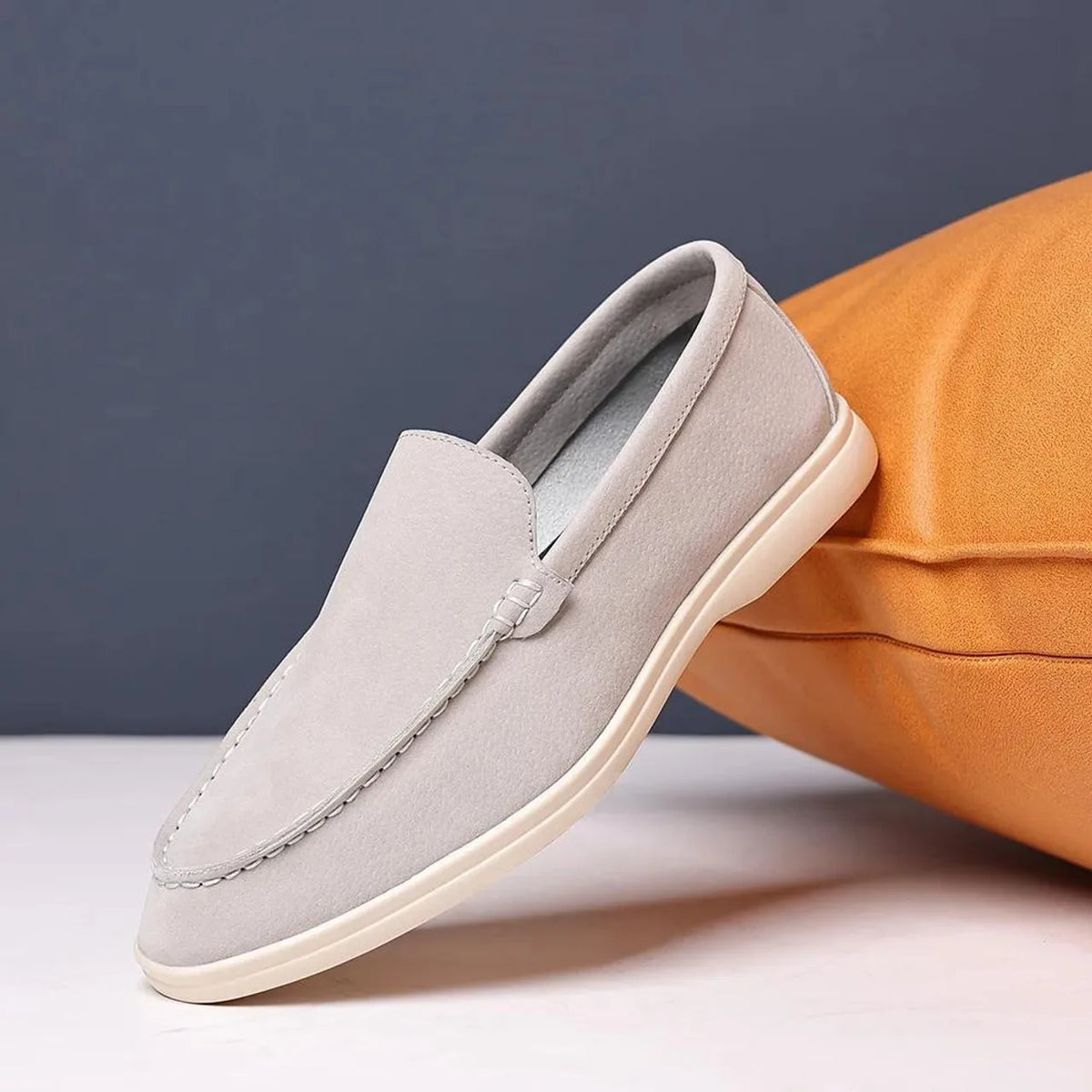 Mocassim casual de camurça cinza claro, sem cadarço, com costuras e solado claro