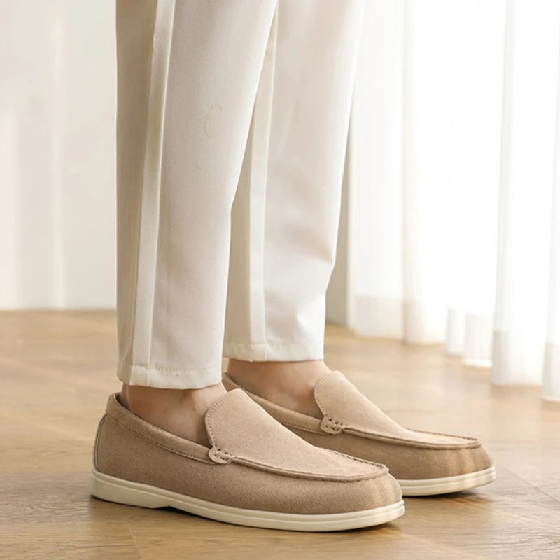 Mocassim Amalfi de camurça bege com sola branca, usando com calça clara.