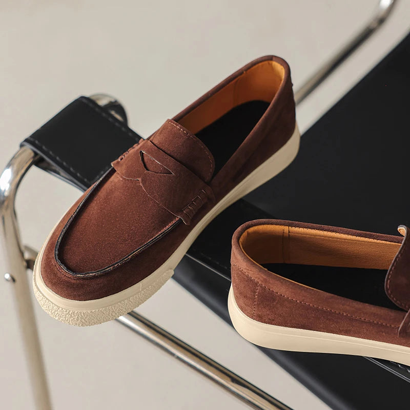 Mocassim tipo loafer marrom escuro de camurça com tira decorativa e solado claro