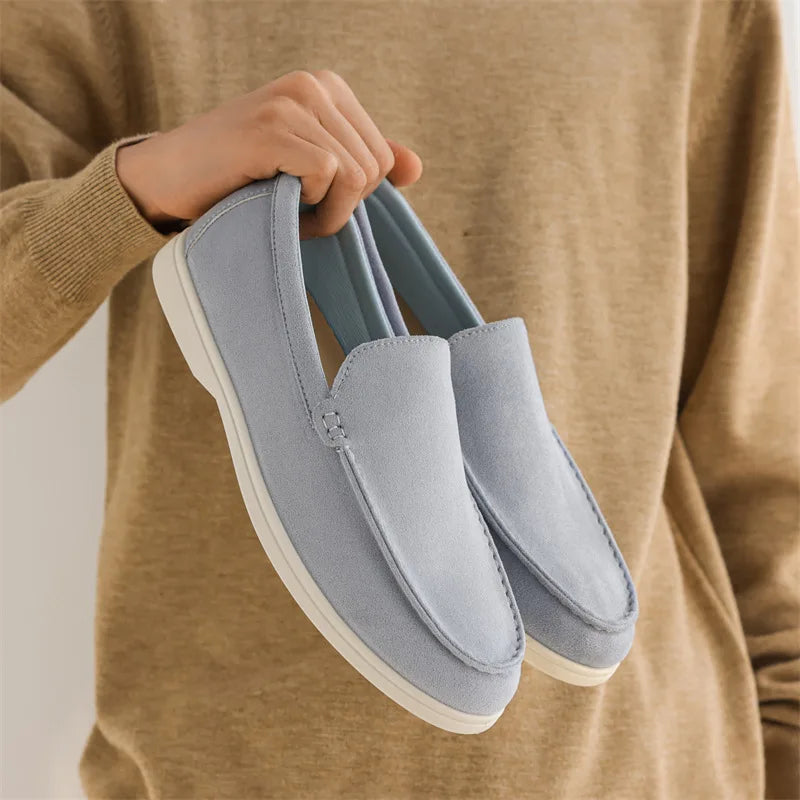 Mocassim Amalfi de camurça azul claro, sola branca e detalhe frontal com costura.