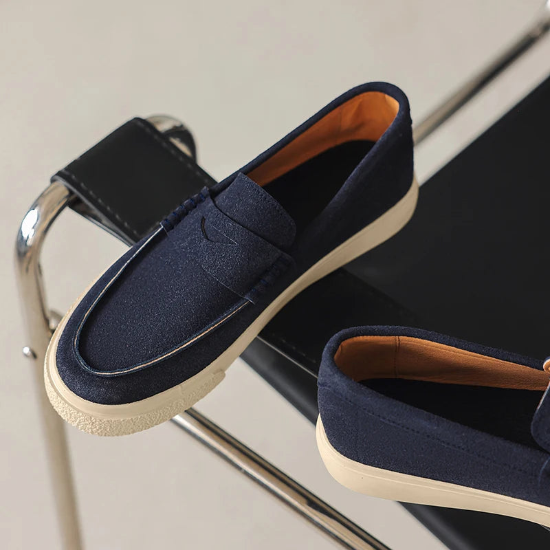 Mocassim tipo loafer azul-marinho de camurça com tira decorativa e solado claro