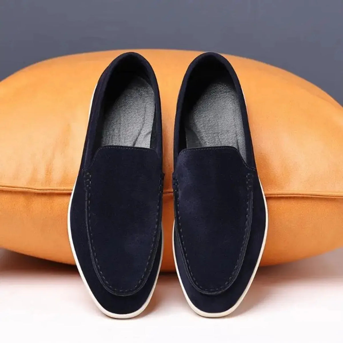 Mocassim casual de camurça azul-marinho, sem cadarço, com costuras e solado branco