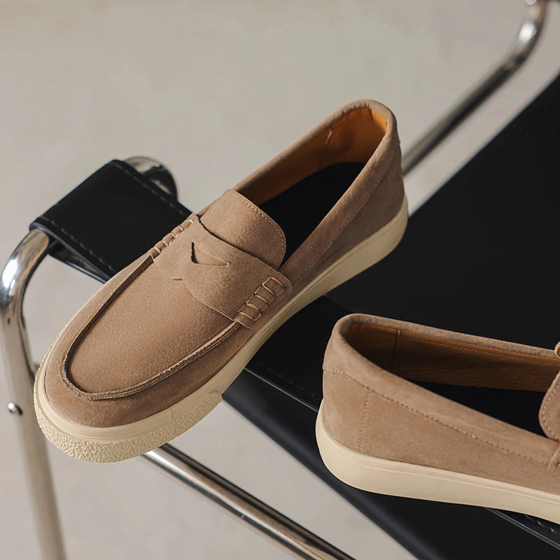 Mocassim tipo loafer bege claro de camurça com tira decorativa e solado claro